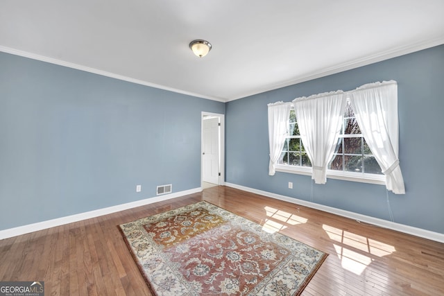 interior space featuring hardwood / wood-style flooring, visible vents, and baseboards