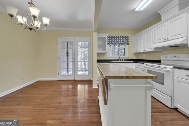 kitchen with white range with electric stovetop, white cabinets, wood counters, under cabinet range hood, and a sink