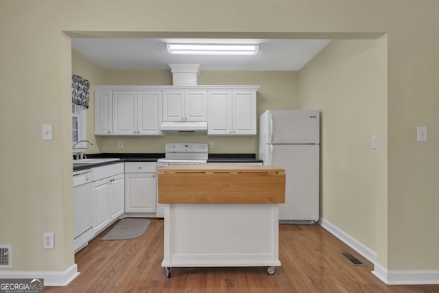 kitchen featuring under cabinet range hood, white appliances, a sink, visible vents, and white cabinets