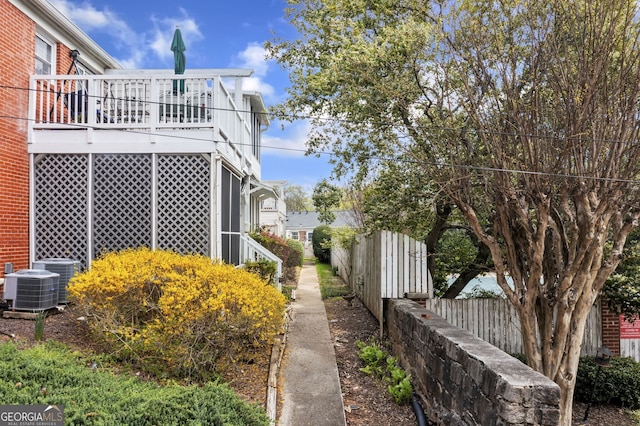 view of side of home featuring fence and central air condition unit