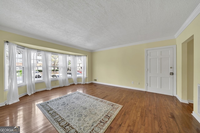 interior space with wood-type flooring, crown molding, baseboards, and a textured ceiling