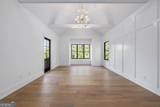 unfurnished room featuring an inviting chandelier, lofted ceiling with beams, and hardwood / wood-style flooring