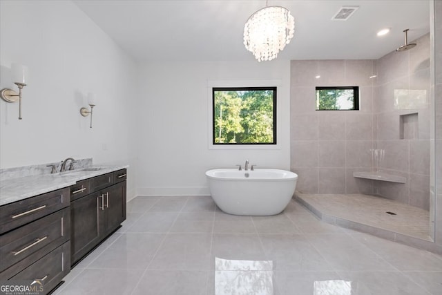 bathroom with tile patterned floors, a notable chandelier, vanity, and independent shower and bath