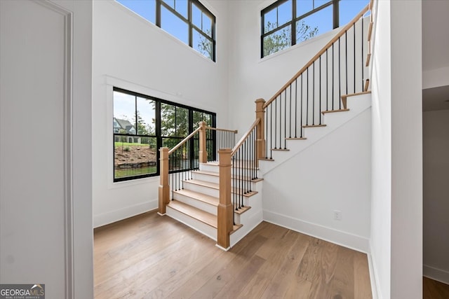 entryway with a towering ceiling and hardwood / wood-style floors