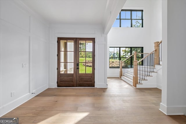 entryway featuring a wealth of natural light, french doors, and light hardwood / wood-style floors