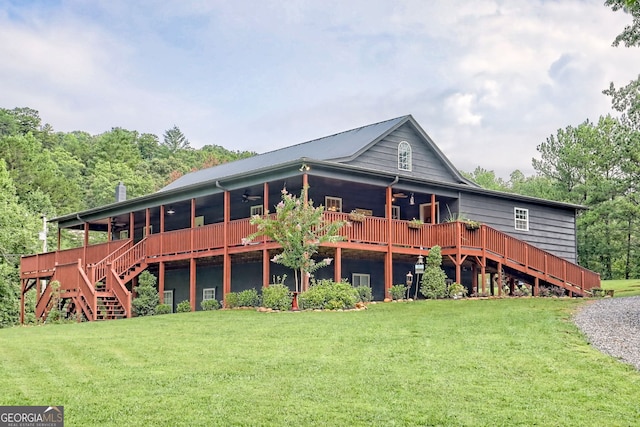 back of property featuring a yard and ceiling fan