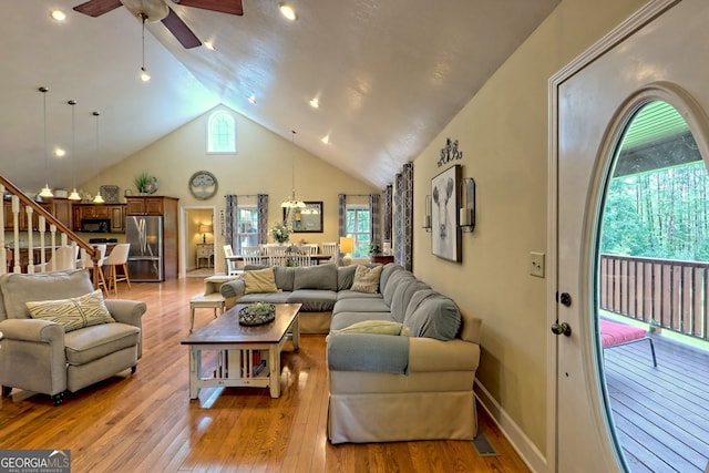 living room with ceiling fan, high vaulted ceiling, and light wood-type flooring