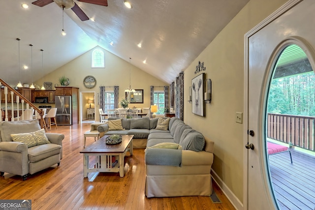 living room with light hardwood / wood-style flooring, high vaulted ceiling, and ceiling fan