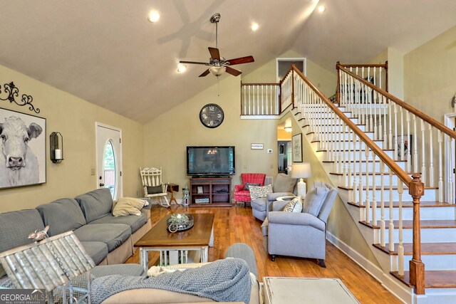 living room featuring high vaulted ceiling, ceiling fan, and light wood-type flooring