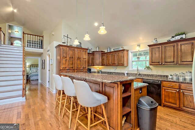 kitchen featuring black dishwasher, a center island, and light wood-type flooring