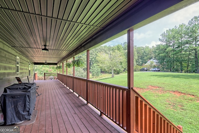 wooden terrace featuring a lawn