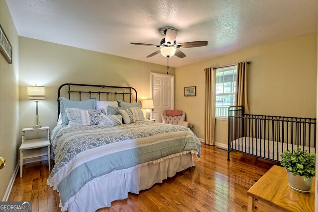 bedroom featuring wood-type flooring, a textured ceiling, and ceiling fan