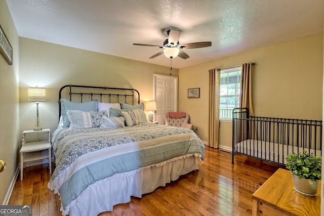 bedroom featuring hardwood / wood-style flooring, ceiling fan, and a textured ceiling