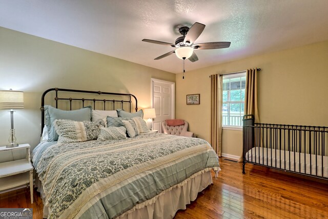 bedroom with wood-type flooring, a textured ceiling, and ceiling fan