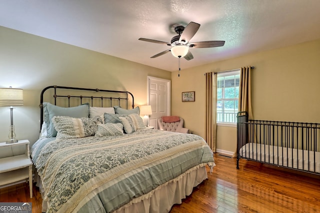 bedroom with ceiling fan and dark hardwood / wood-style floors