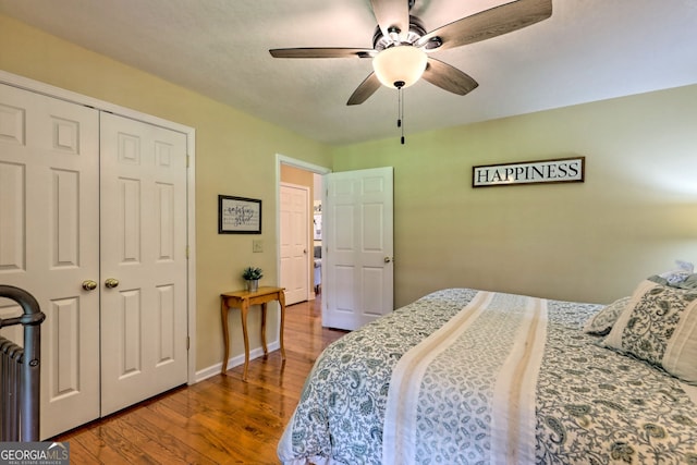 bedroom with a closet, hardwood / wood-style flooring, and ceiling fan