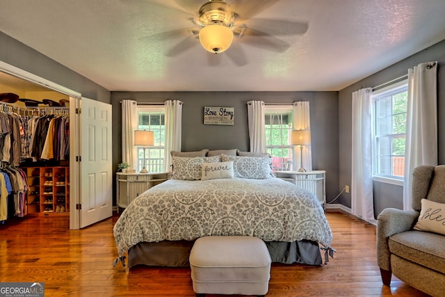 bedroom with wood-type flooring, a closet, and ceiling fan