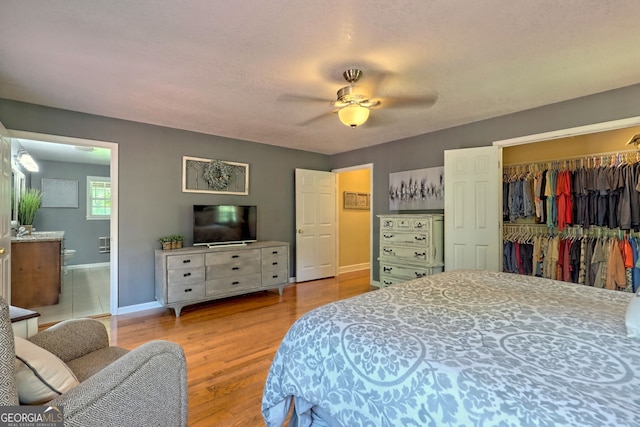 bedroom with hardwood / wood-style flooring, ceiling fan, ensuite bathroom, a spacious closet, and a closet