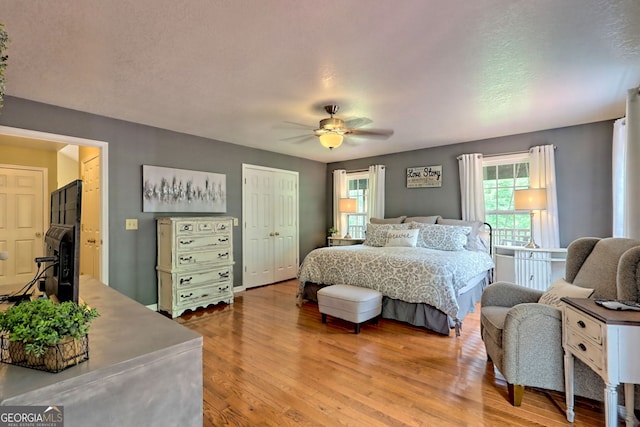 bedroom featuring ceiling fan, hardwood / wood-style floors, and a closet