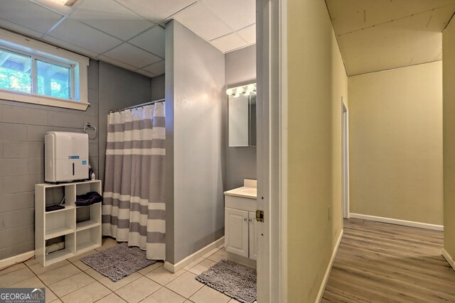 bathroom with a drop ceiling, tile patterned floors, and vanity