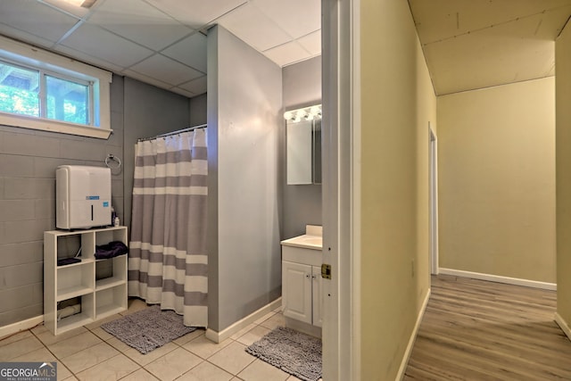 bathroom with vanity, tile patterned flooring, and a paneled ceiling