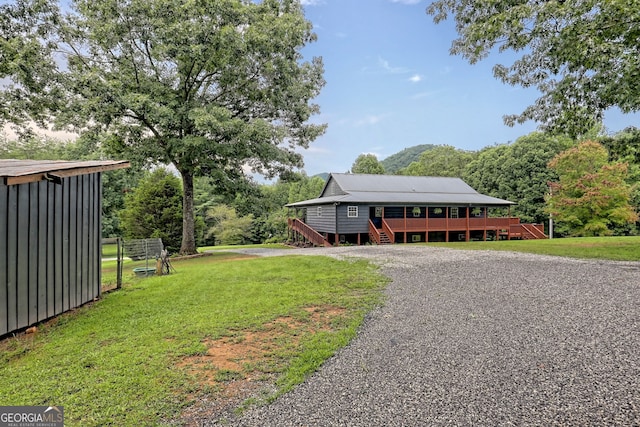 view of front of property featuring a front yard and a deck