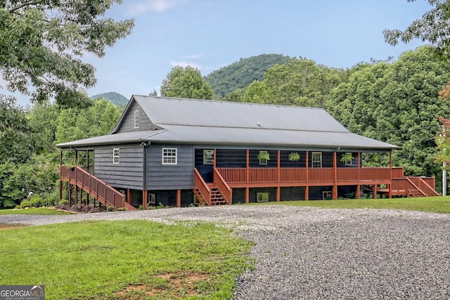 view of front of home with a mountain view and a front lawn