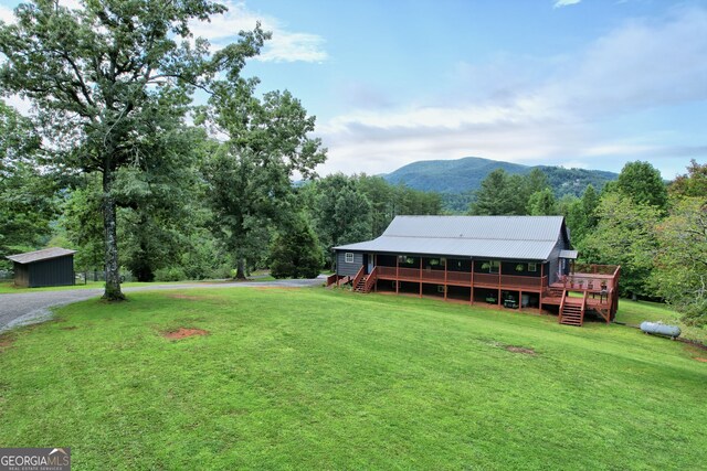 view of yard featuring an outbuilding and a deck with mountain view