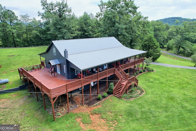 back of property featuring a wooden deck and a yard