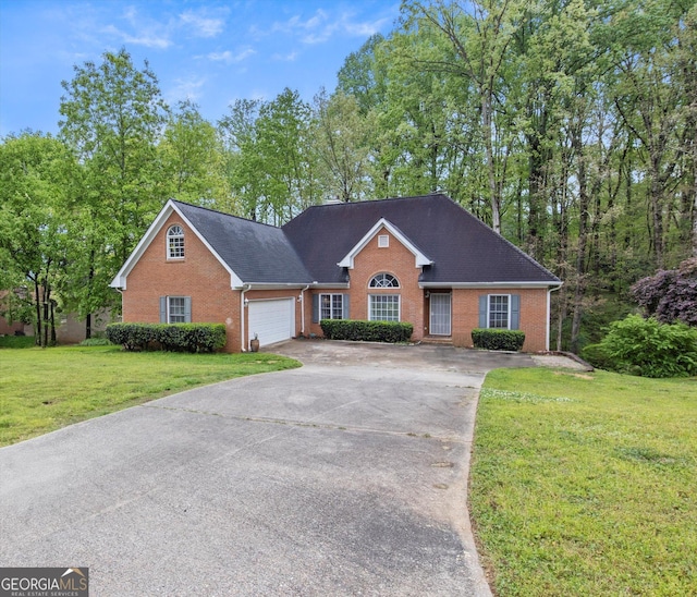 140 Wisteria Blvd, Covington, GA 30016 - view of front of home featuring concrete driveway, a front yard, a shingled roof, a garage, and brick siding