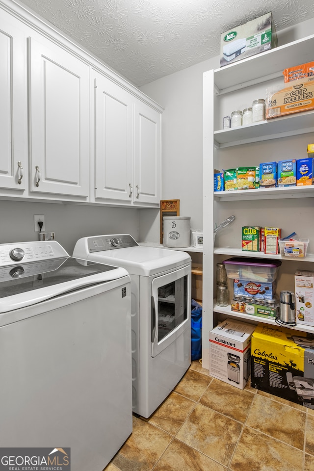 washroom with light tile patterned flooring, separate washer and dryer, cabinets, and a textured ceiling