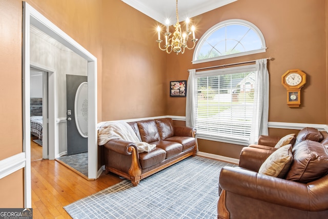 living room featuring a notable chandelier, crown molding, and light wood-type flooring