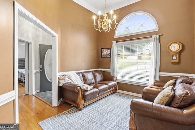 140 Wisteria Blvd, Covington, GA 30016 - living room with baseboards, a notable chandelier, a towering ceiling, and hardwood / wood-style flooring