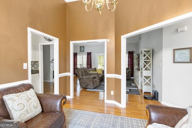 140 Wisteria Blvd, Covington, GA 30016 - living area with baseboards, an inviting chandelier, wood finished floors, and a towering ceiling