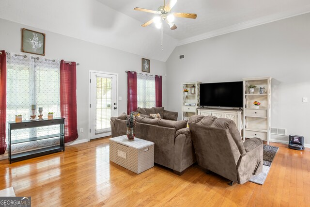 living room with vaulted ceiling, ornamental molding, ceiling fan, and light hardwood / wood-style floors