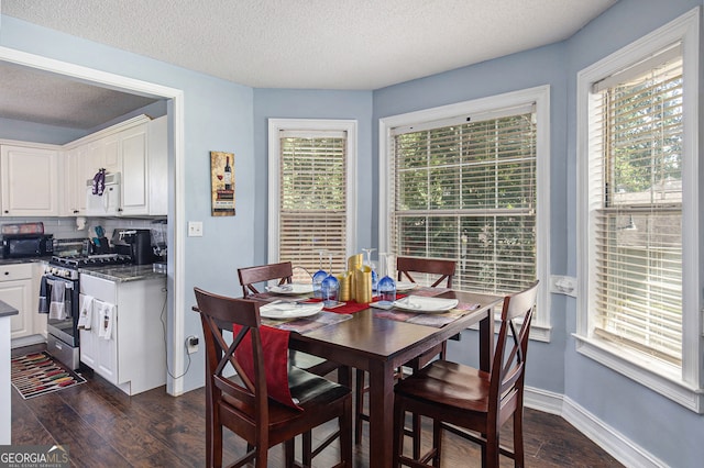 dining area with plenty of natural light, dark hardwood / wood-style floors, and a textured ceiling