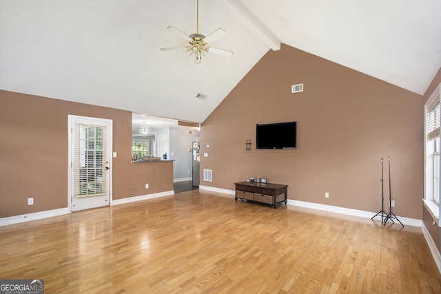 unfurnished living room featuring ceiling fan with notable chandelier, beamed ceiling, light hardwood / wood-style flooring, and high vaulted ceiling