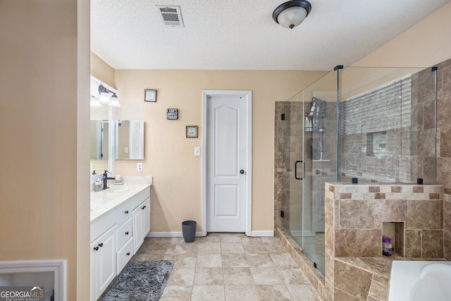 bathroom featuring vanity, plus walk in shower, tile patterned flooring, and a textured ceiling