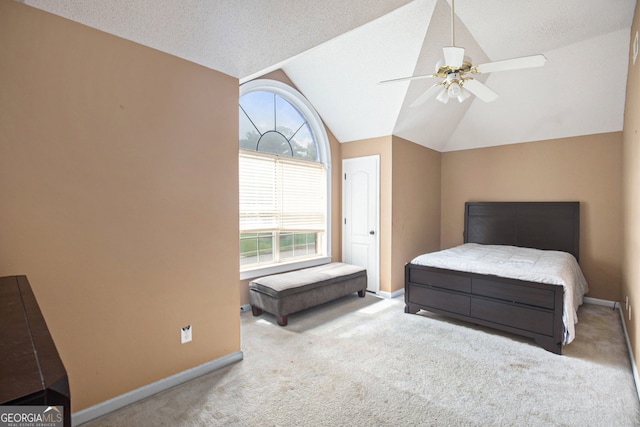 bedroom featuring light carpet, vaulted ceiling, a textured ceiling, and ceiling fan