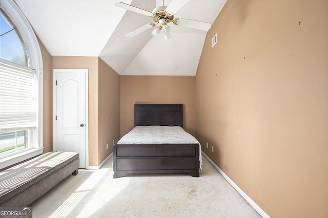 bedroom featuring ceiling fan, vaulted ceiling, and light colored carpet