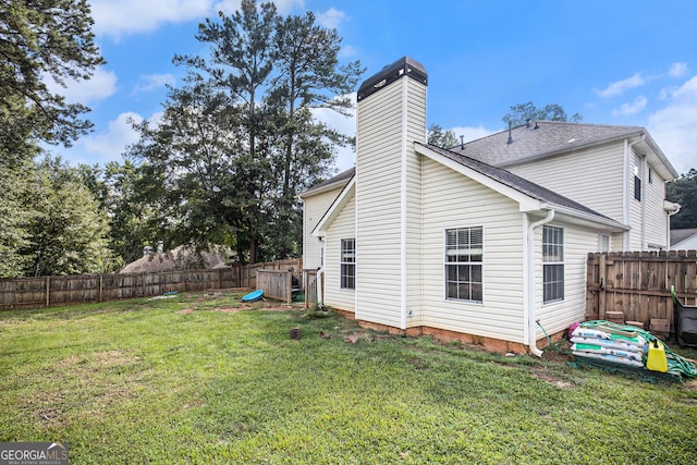 back of house featuring a lawn