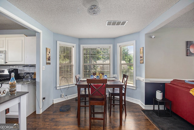 dining room featuring dark hardwood / wood-style flooring and a textured ceiling