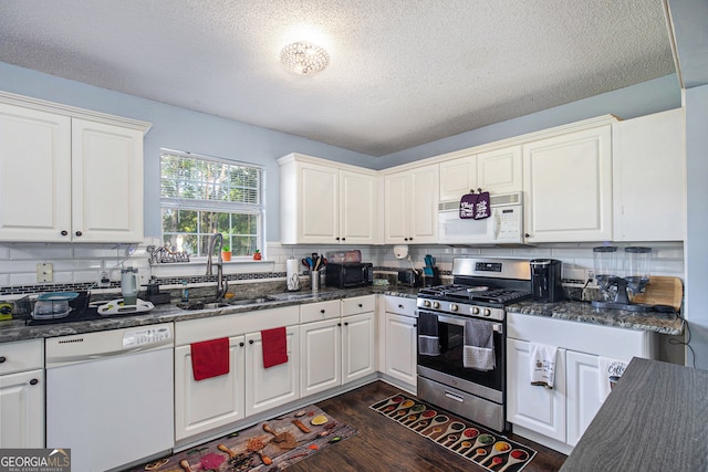 kitchen featuring white cabinetry, white appliances, and backsplash