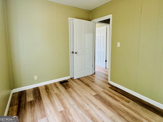 unfurnished room featuring light hardwood / wood-style floors and crown molding