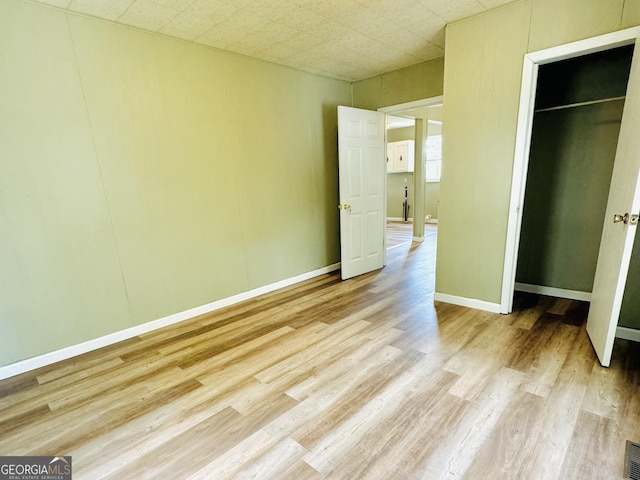 unfurnished bedroom with light hardwood / wood-style floors and a closet