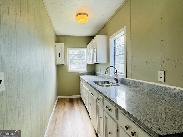 kitchen featuring plenty of natural light, white cabinets, and sink