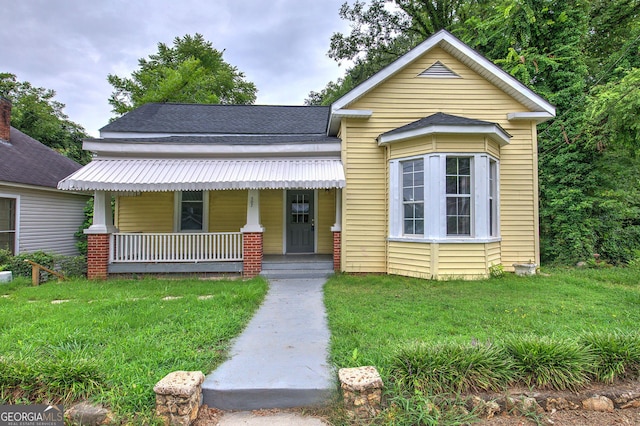 view of front of property with covered porch and a front yard