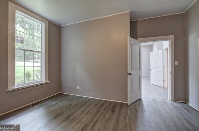 spare room with hardwood / wood-style flooring and ornamental molding