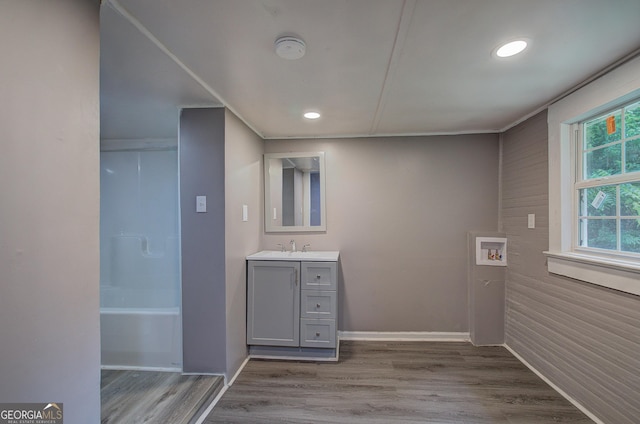 interior space featuring bathing tub / shower combination, vanity, and hardwood / wood-style flooring