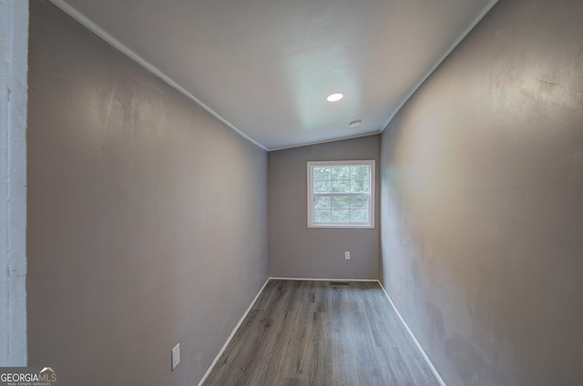 unfurnished room featuring lofted ceiling and hardwood / wood-style floors